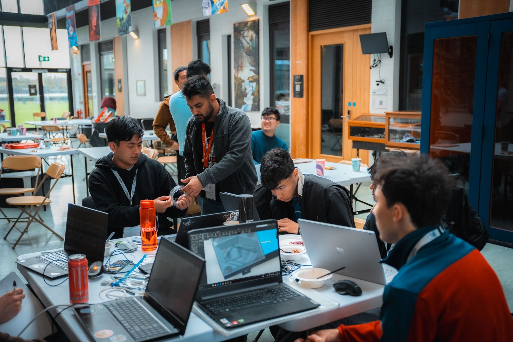 A team working together around laptops and hardware on the Saturday of the hackathon